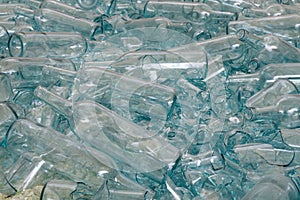 Large pile of blue tinted glass bottles with some broken at a recycling plant