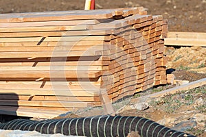 A large pile of boards sawn from trees on a sawmill for the procurement of building materials for construction