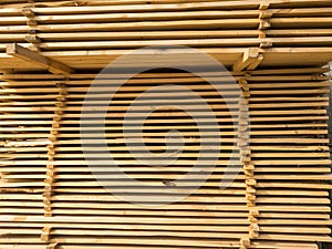 A large pile of boards sawn from trees on a sawmill for the procurement of building materials for construction. Construction