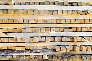 A large pile of boards sawn from trees on a sawmill for the procurement of building materials for construction. Construction