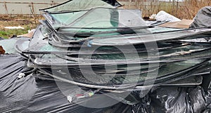 A large pile of broken auto glass in a garbage dump.