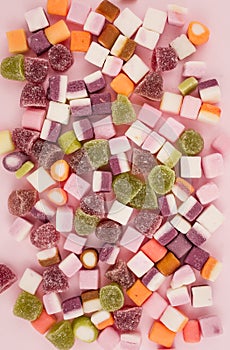 A large pile of mixed sweets on wooden background