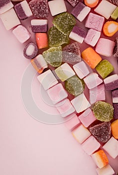 A large pile of mixed sweets on wooden background