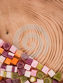 A large pile of mixed sweets on wooden background