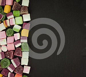 A large pile of mixed sweets on wooden background