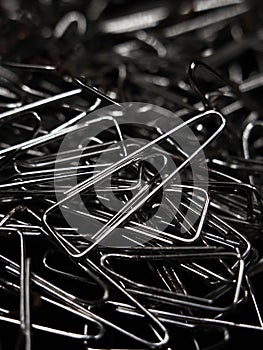 a large pile of triangular shaped shiny silver paper clips