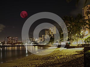 Large pink moon over the skies of Waikiki Beach Honolulu Hawaii Island USA