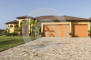 Large pink and yellow tropical house with circular driveway.