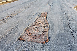 A large pit on the road, laid with old bricks.  The repair of the road without a monetary investment. Life hack