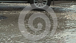 Large pits on the asphalt, road infrastructure damaged by rain.