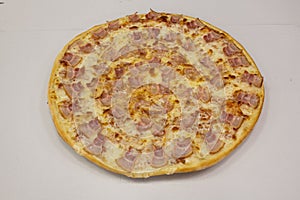 Large pizza with lots of bacon pieces of the same size placed almost mathematically on top of the melted mozzarella cheese photo