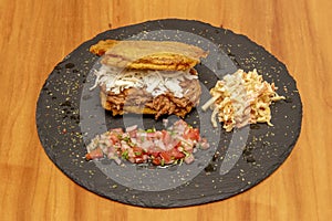 Large plantain patacon stuffed with cheese and shredded meat with cole slaw and pico de gallo