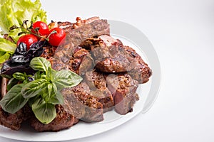 A large plate of meat assorted cooked on a grill