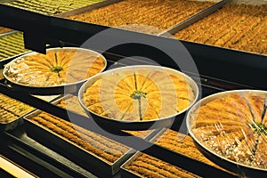 Large plates of Arabic sweet baklava or baklawa on the shelves of store window