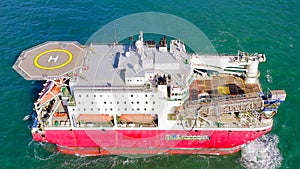 Large Platform supply ship with Helipad and two large cranes, anchored at Sea.