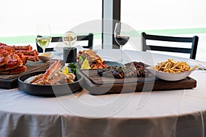 large platter of seafood, steak, fries, sides, and wines