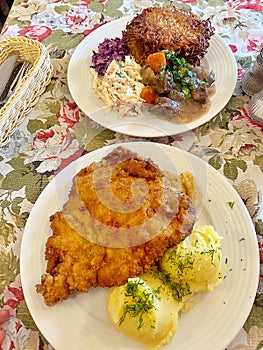 large pork chop, breading on the cutlet, mashed potatoes, lunch dish, typical Polish dinner, potato pancakes with goulash
