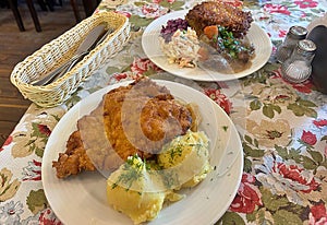 large pork chop, breading on the cutlet, mashed potatoes, lunch dish, typical Polish dinner, potato pancakes with goulash photo