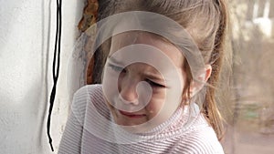 a large portrait of a little crying girl with tears flowing from her eyes. children's tears.