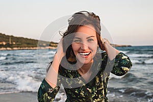 Large portrait of a young woman on the beach at red sunset, selfie, smile, fun, vacation