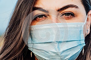 Large portrait of a young woman in a medical mask