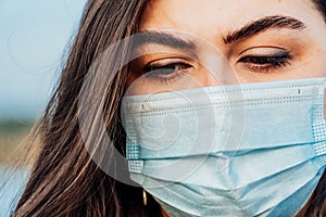 Large portrait of a young woman in a medical mask