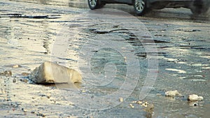 Large potholes on the asphalt, damaged road infrastructure after rain.