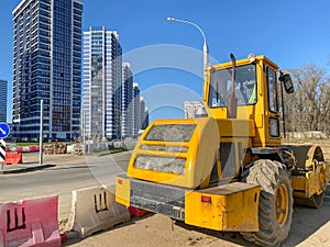 Large powerful modern yellow roller for asphalt paving, repair and road construction. New construction machinery and equipment at