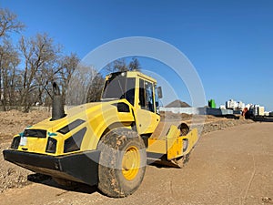 Large powerful modern yellow roller for asphalt paving, repair and road construction. New construction machinery and equipment at
