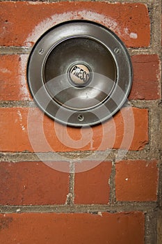 Large press button doorbell brick wall