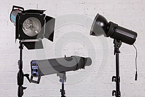 Large professional photo studio lamps on a white brick wall