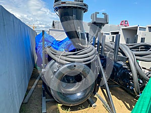 A large pump with an impeller and an impeller stands in a storage warehouse prepared for installation of industrial metal