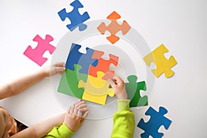 A large puzzle of colorful parts in the hands of a child