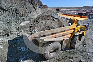 Large quarry dump truck. Loading the rock in the dumper. Loading