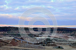 Large quarry dump truck. View of the large sand pit. Production useful minerals. Loading the rock.