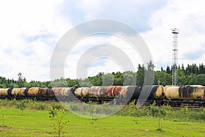A large railway train with many tank cars carries goods by rail. Rail transportation of liquid cargo
