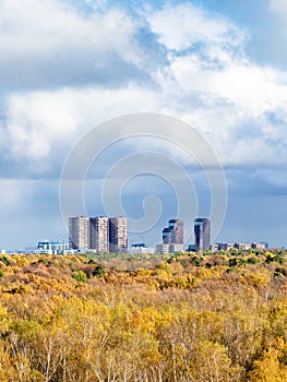 Large rainy clouds over yellow forest and town