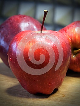 A large red apple of the Red Chief variety, a close-up shot. Water droplets on the apple peel. Ripe fruit