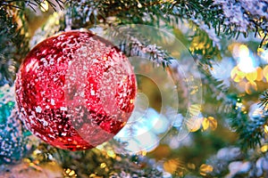 A large red ball covered with snow as a decoration for the New Years celebration. Winter christmas tree with bauble