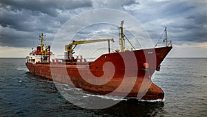 Large red cargo ship sailing in open sea