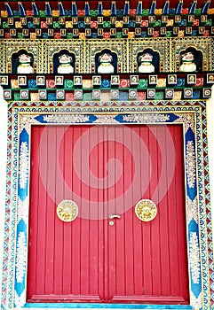 large red door with gold handles statues of temple guardian dogs photo