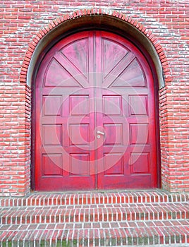 large red doorway with red brick wall or steps photo