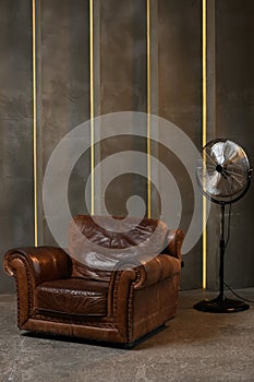 a large red leather chair against a textured wall. the interior of the loft has a dark floor