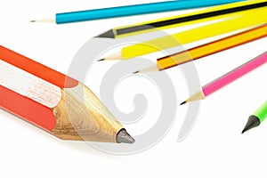 A large red pencil and a group of small multi-colored pencils on a white background