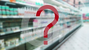 Large red question mark on blur supermarket background. Defocused shelves with milk, dairy products. Grocery Store. Retail