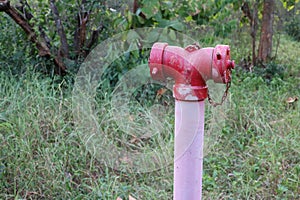 Large red steel pipe, water supply fire suppression system located outdoors.