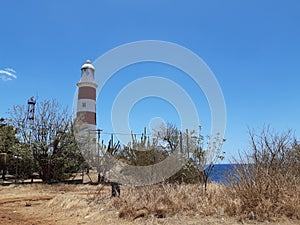Large red and white lighthouse in Mauritius coast Albion on a sunny day. photo