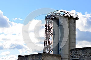 Large reinforced concrete pipe construction with a metal ladder against a bright blue sky