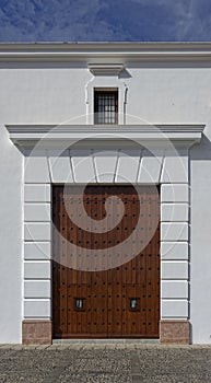 A large reinforced wooden side door of a whitewashed wall in a Church in the Spanish Town of Antequerra. photo