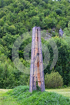 A large retro wooden clip on a meadow pinches the grass